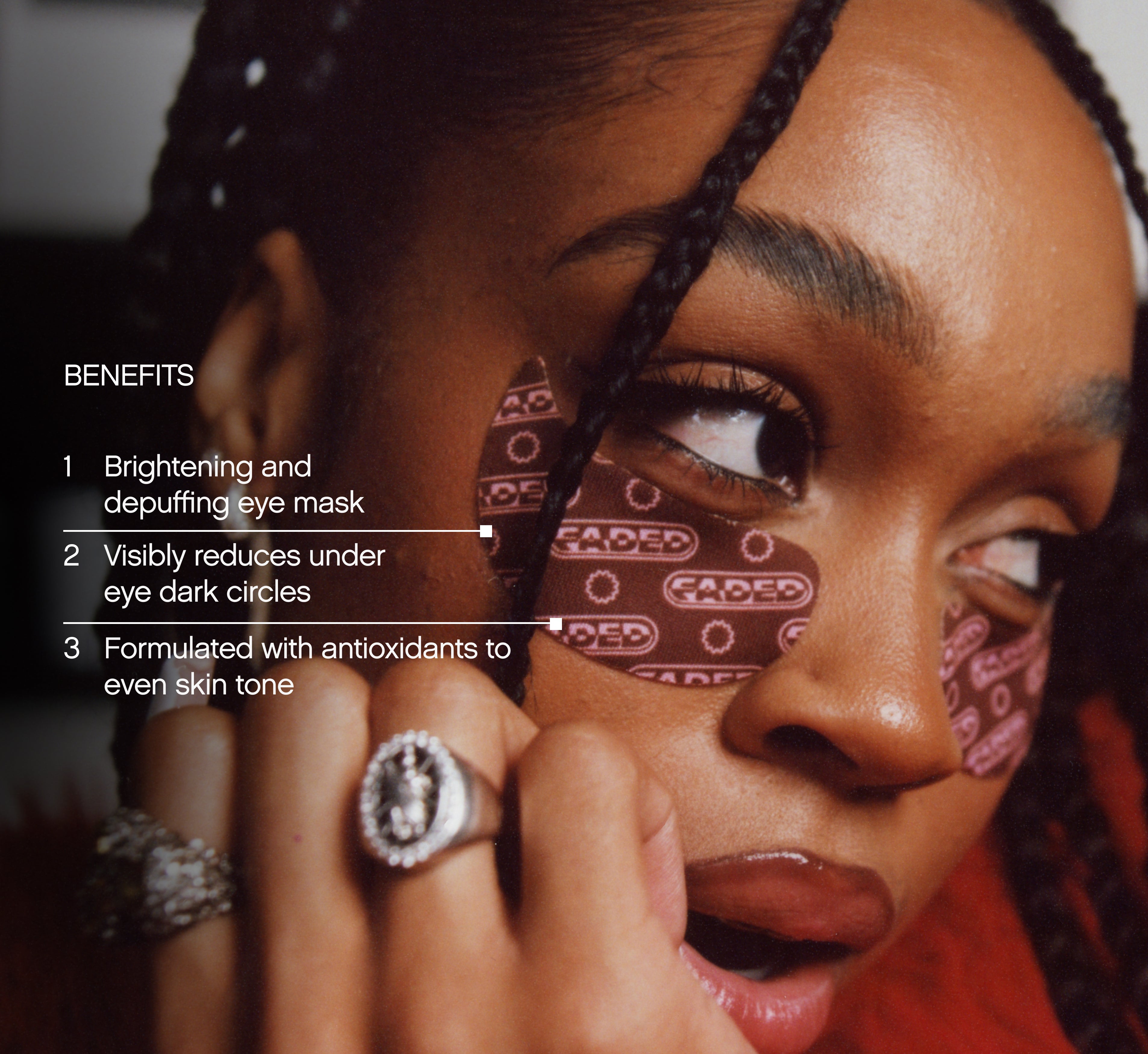 Brightening under eye patches from Topicals Faded shown applied beneath a Black woman's eye with benefits callouts for depuffing, dark circle reduction, and skin tone evening.